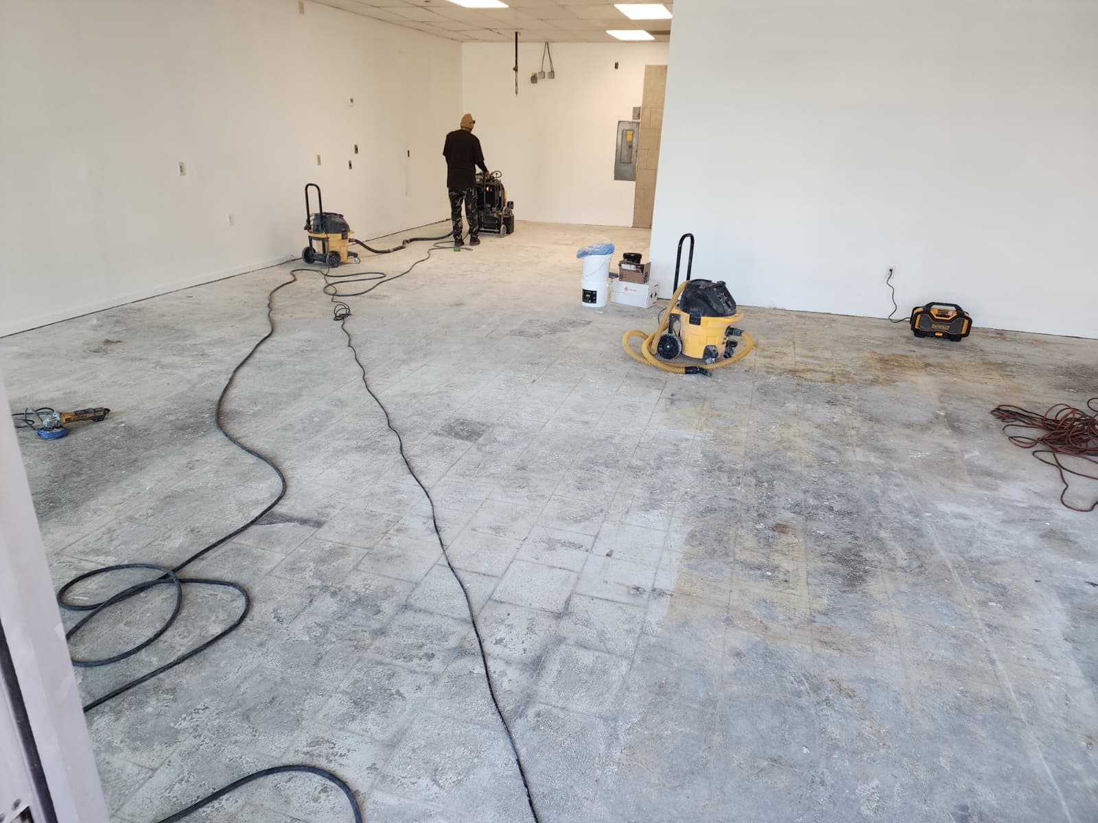 Commercial concrete floor before epoxy installation in Fairfax VA with surface preparation in progress