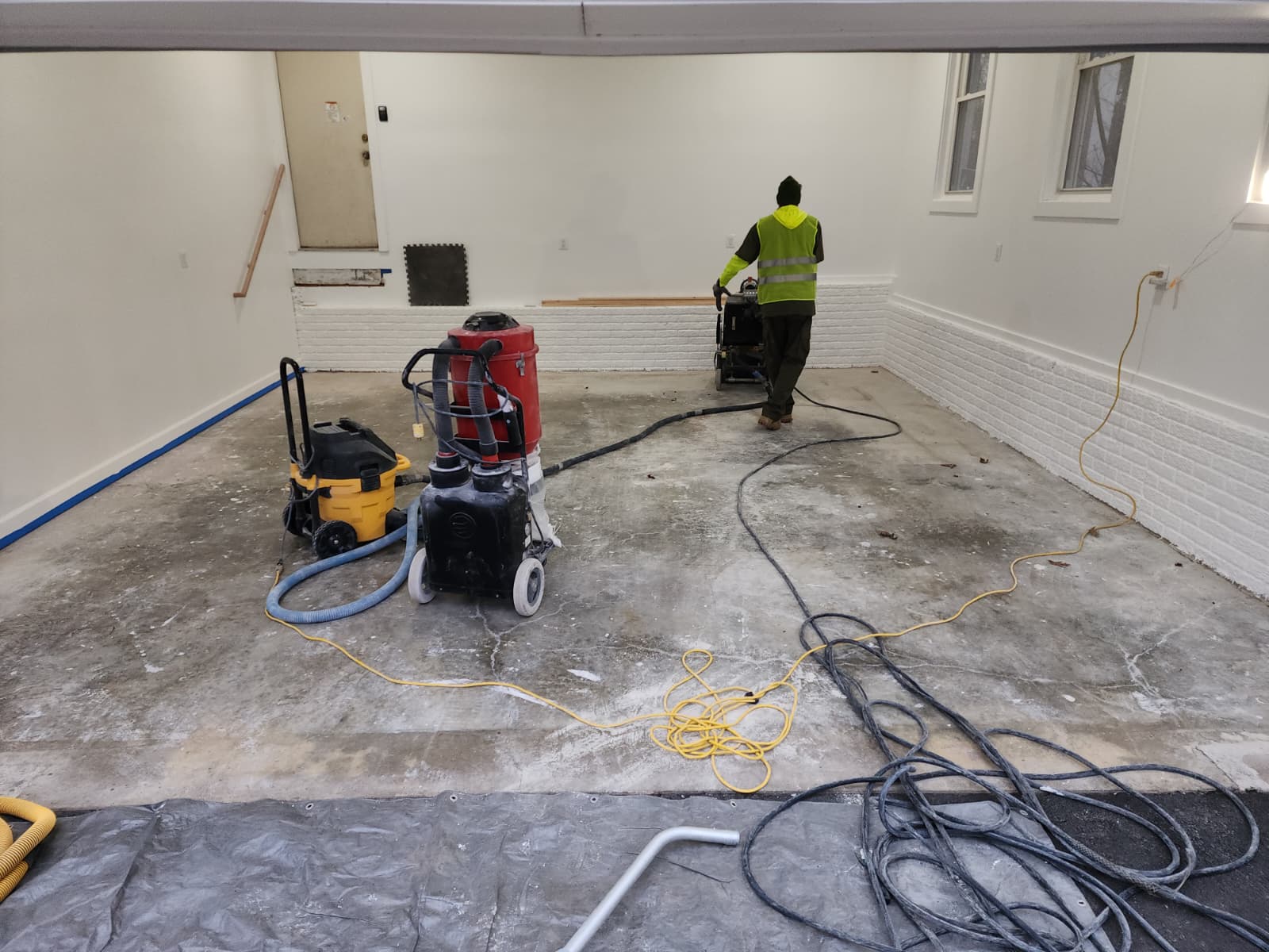Garage floor before epoxy coating with cracked and worn concrete surface
